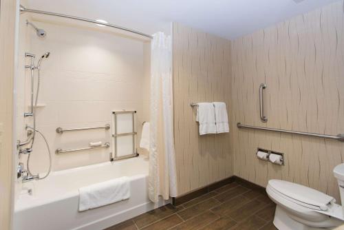 a bathroom with a tub and a toilet and a shower at Hilton Garden Inn Dayton South - Austin Landing in Springboro