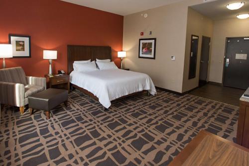 a hotel room with a bed and a chair at Hilton Garden Inn Dayton South - Austin Landing in Springboro