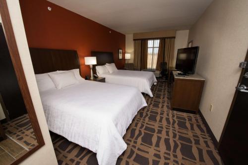 a hotel room with two beds and a flat screen tv at Hilton Garden Inn Dayton South - Austin Landing in Springboro