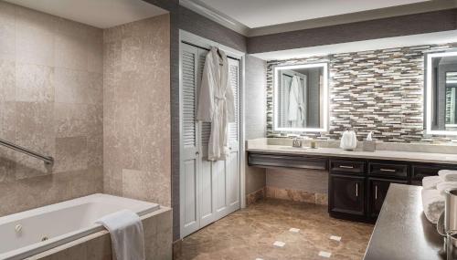 a bathroom with a tub and a sink at DoubleTree by Hilton Dallas Near the Galleria in Dallas