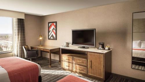a hotel room with a bed and a flat screen tv at DoubleTree by Hilton Dallas Near the Galleria in Dallas