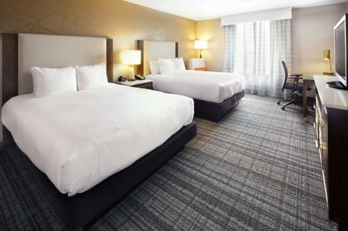 a hotel room with two beds and a desk at DoubleTree by Hilton Dallas Near the Galleria in Dallas