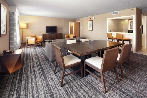 a living room and dining room with a table and chairs at DoubleTree by Hilton Dallas Near the Galleria in Dallas