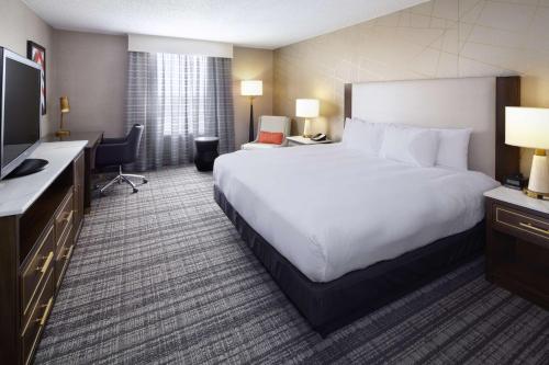 a hotel room with a large bed and a television at DoubleTree by Hilton Dallas Near the Galleria in Dallas