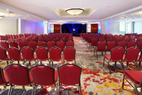 a conference room with red chairs and a stage at DoubleTree by Hilton Dallas Near the Galleria in Dallas