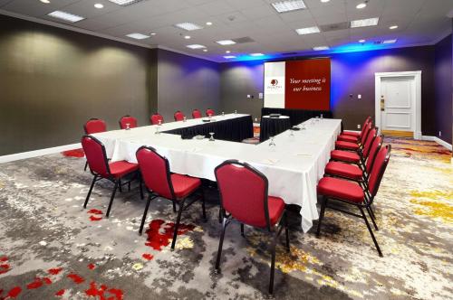 a conference room with a long table and red chairs at DoubleTree by Hilton Dallas Near the Galleria in Dallas
