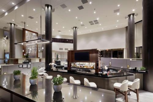 a lobby with a bar with white chairs at DoubleTree by Hilton Dallas Near the Galleria in Dallas