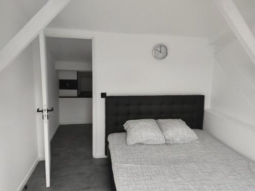 une chambre avec un lit et une horloge au mur dans l'établissement Zara at Saint Raphael France, à Saint-Raphaël