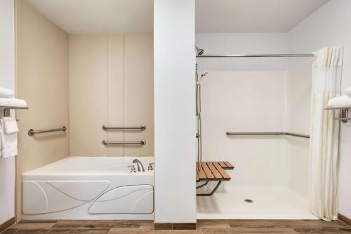 a white bathroom with a tub and a shower at Hilton Garden Inn Dubuque Downtown in Dubuque