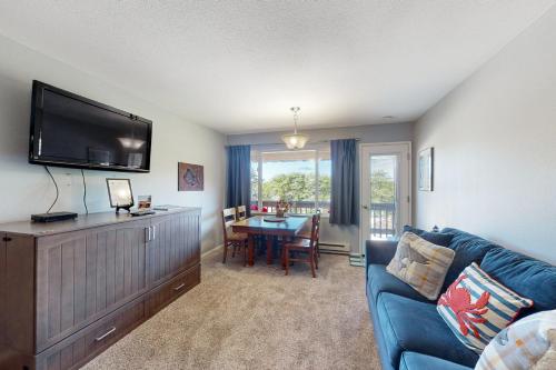 a living room with a blue couch and a television at Coastal Vista in Neskowin