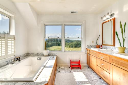 un bagno con vasca, 2 lavandini e una sedia rossa di Rainier Home on 20 Acres with Blueberry Farm! a Kalama