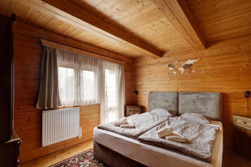 a bedroom with a bed in a wooden room at Private summer house with swimming pool, beach bar and pit for football and volleyball in Hvězdonice
