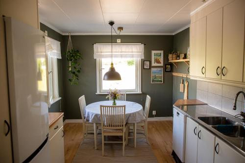 a kitchen with a table with chairs and a window at Cozy mountain view apartment in Orrviken