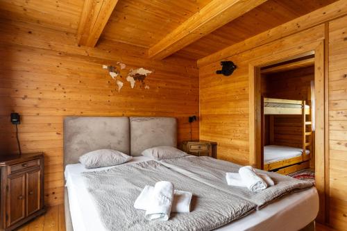 a bedroom with a bed in a wooden cabin at Private summer house with swimming pool, beach bar and pit for football and volleyball in Hvězdonice