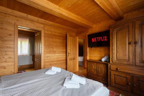a bedroom with a bed in a wooden room at Private summer house with swimming pool, beach bar and pit for football and volleyball in Hvězdonice