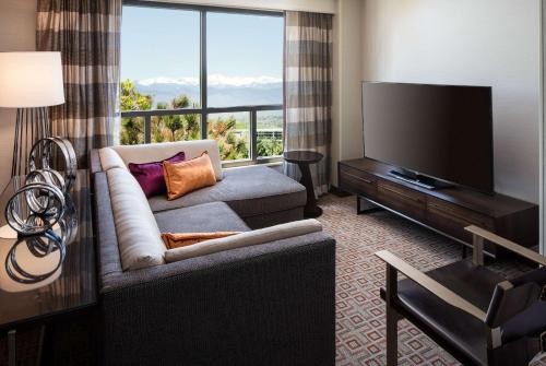 a living room with a couch and a flat screen tv at DoubleTree by Hilton Denver Tech in Greenwood Village