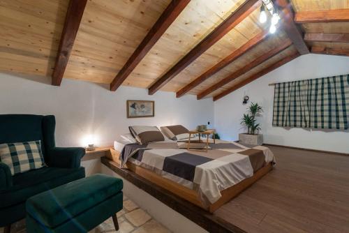 a bedroom with a large bed and a chair at Trapula stone paradise in Maslinica