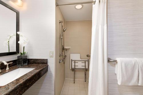 uma casa de banho com um lavatório e um chuveiro em DoubleTree by Hilton Hotel Denver - Thornton em Thornton