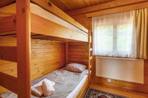 a bedroom with two bunk beds and a window at Private summer house with swimming pool, beach bar and pit for football and volleyball in Hvězdonice
