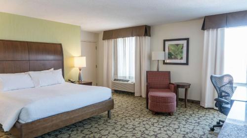 une chambre d'hôtel avec un lit et une chaise dans l'établissement Hilton Garden Inn Plymouth, à Plymouth