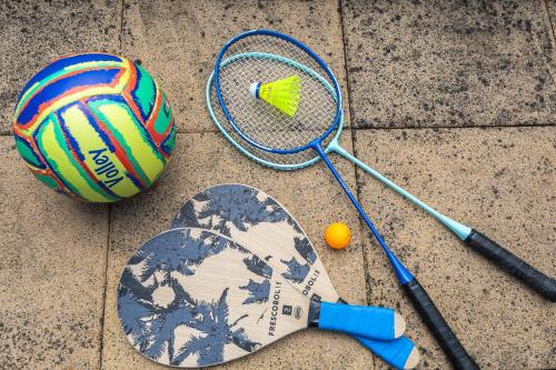 a tennis racket and a ball on the ground at Private summer house with swimming pool, beach bar and pit for football and volleyball in Hvězdonice
