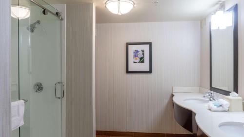 Hilton Garden Inn Plymouth في بليموث: حمام مع حوض ومرحاض ومرآة