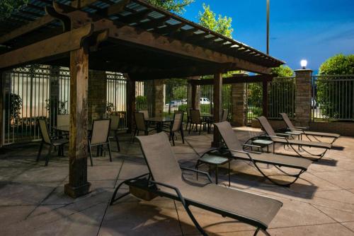 a group of chairs and tables on a patio at Hilton Garden Inn Denton in Denton