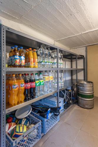 a refrigerator filled with lots of bottles of orange soda at Private summer house with swimming pool, beach bar and pit for football and volleyball in Hvězdonice