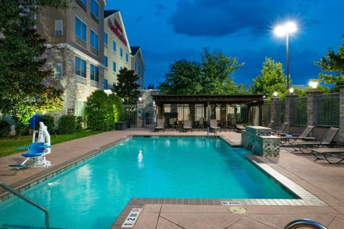 a swimming pool in front of a building at Hilton Garden Inn Denton in Denton