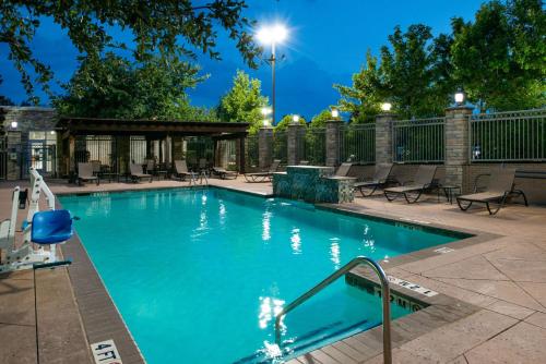 a swimming pool with blue water in a building at Hilton Garden Inn Denton in Denton