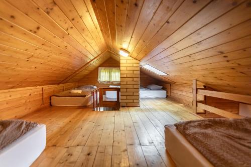 a large wooden room with two beds in a cabin at Private summer house with swimming pool, beach bar and pit for football and volleyball in Hvězdonice