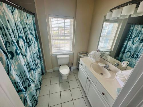 a bathroom with a toilet and a sink and a mirror at Seahawk South B in Fort Morgan
