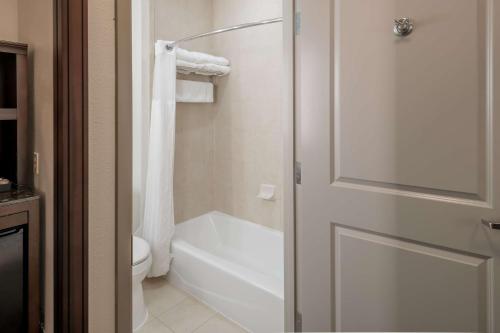 a bathroom with a white toilet and a shower door at Hilton Garden Inn Granbury in Granbury