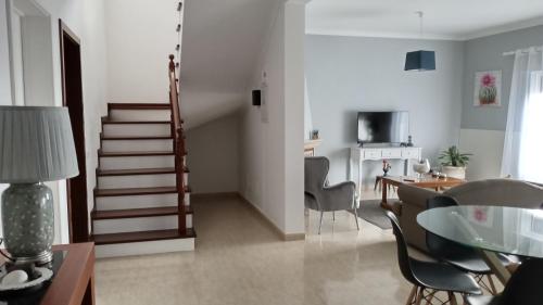 a living room with a staircase and a table and chairs at Areal de Santa Bárbara Sea View in Ribeira Grande