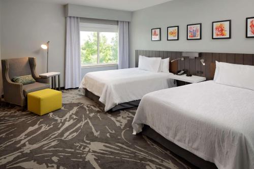 Habitación de hotel con 2 camas, silla y ventana en Hilton Garden Inn DFW Airport South, en Irving