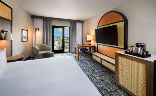 a hotel room with a bed and a flat screen tv at Hilton Dallas Southlake Town Square in Southlake
