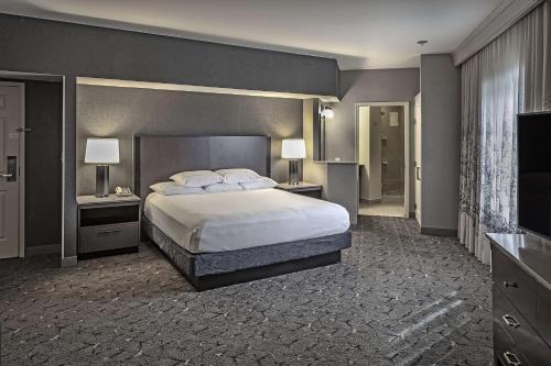 a bedroom with a large bed with two night stands and two lamps at DoubleTree by Hilton Modesto in Modesto