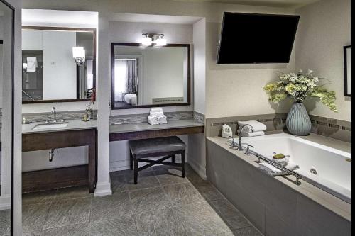a bathroom with a tub and a sink and a bath tub at DoubleTree by Hilton Modesto in Modesto