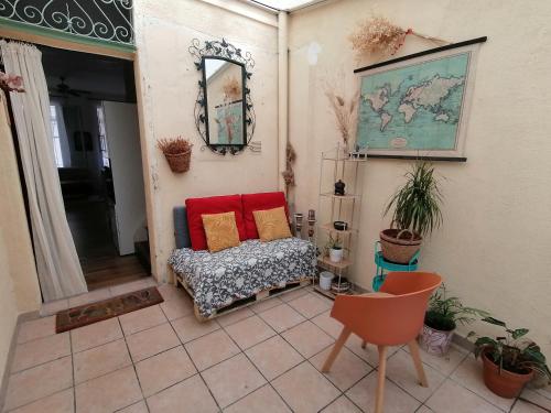 Cette chambre comprend un canapé, une table et un miroir. dans l'établissement Jolie maison avec terrasse au centre-ville d'Arles, à Arles