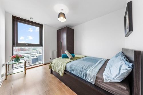 a bedroom with a bed and a large window at Mascutstay 2 Beds London skyline view in London