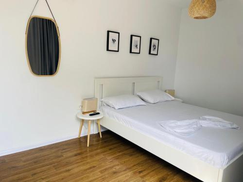 a bedroom with a white bed and a mirror at Daro tiny house in Vama Veche