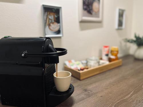 a coffee maker with a cup on a table at Borisz Apartman in Makó