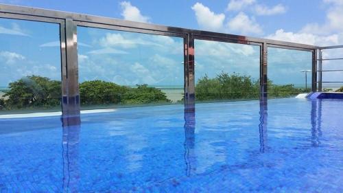 uma piscina com vista para o oceano em Flat na Orla de Tambaú em João Pessoa
