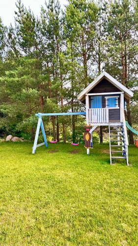 a play house with a slide in a yard at Cisowe Sioło in Jeleniewo