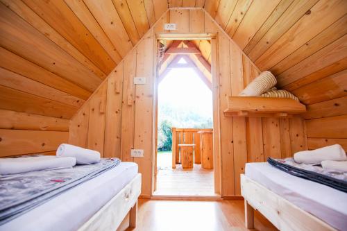 um quarto com duas camas numa casa de madeira em Apartmaji Pri Kozmavo - Little House em Bohinj