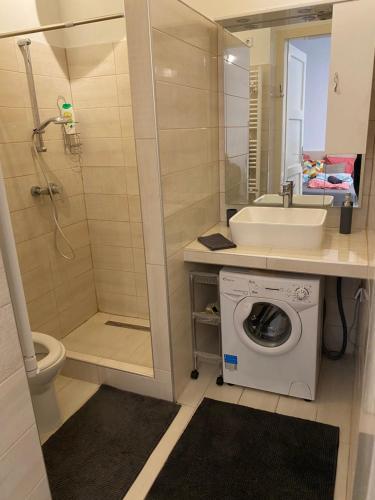 La salle de bains est pourvue d'un lavabo et d'un lave-linge. dans l'établissement Habibi Apartman, à Budapest