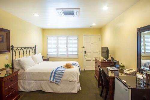 a bedroom with a bed and a television in it at Castillo Inn at the Beach in Santa Barbara