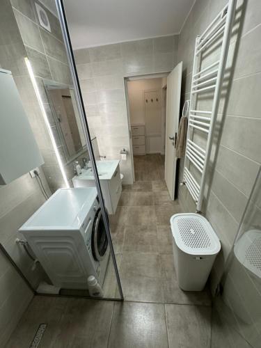 a bathroom with a sink and a washing machine at Apartament Anastasia Residence in Oradea