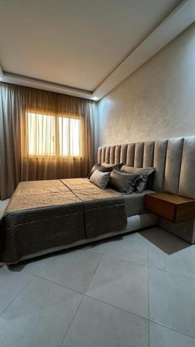 Cette chambre comprend un grand lit et une fenêtre. dans l'établissement Appartement Ferdaous, à Agadir