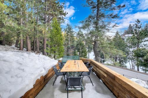 une table et des chaises sur une terrasse enneigée dans l'établissement The Mod Lodge - Lake Arrowhead, à Lake Arrowhead